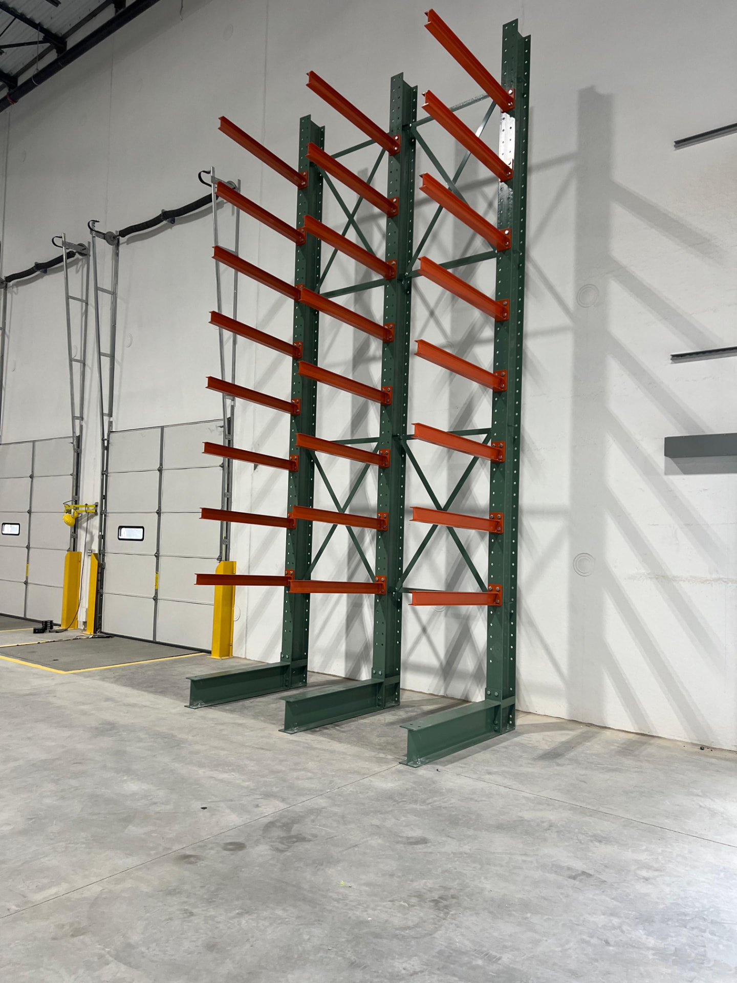 Cantilever rack with green columns and orange arms for long material storage