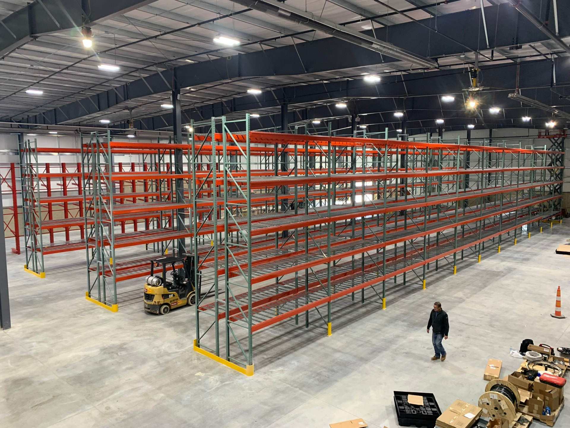 Warehouse pallet rack installation with a forklift working in a wide open storage area