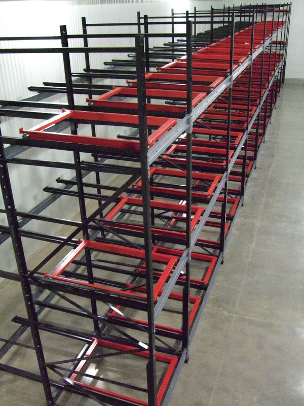 Push back pallet rack system with carts on inclined rails for high-density storage